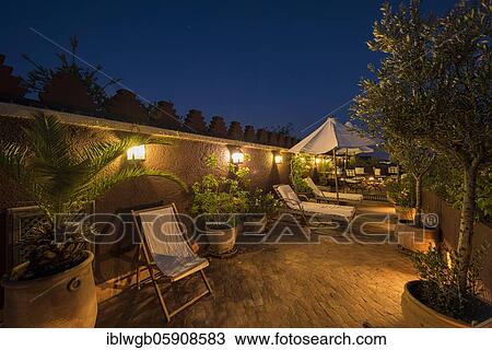 Stock Image - Roof terrace of a riad in the evening light, Moroccan hotel, Marrakesh, Morocco, Africa. Fotosearch