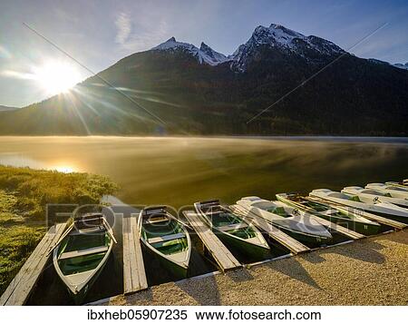Rowing boats at Hintersee with morning fog at sunrise, in the back Hochkalter, Berchtesgaden National Park, Ramsau, Upper Bavaria, Bavaria, Germany, Europe View Large Photo Image Stock Photography - Rowing boats at Hintersee with morning fog at sunrise, in the back Hochkalter, Berchtesgaden National Park, Ramsau, Upper Bavaria, Bavaria, Germany, Europe. Fotosearch