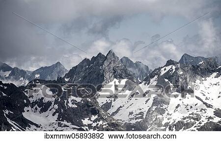 Stock Image - Rugged mountain peaks, Hornspitze or Berliner Spitze, snow-covered mountains, high alpine landscape in fog, Berliner Höhenweg, Zillertaler Alps, Zillertal, Tyrol, Austria, Europe. Fotosearch