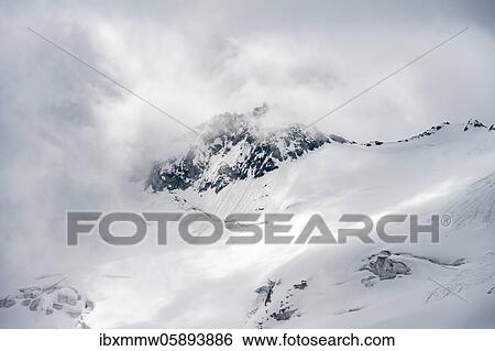 Stock Photograph - Rugged mountain peaks, Rossgruspitz with break-off edge, Waxeggkees glacier, snow-covered mountains, high alpine landscape in fog, Berliner Höhenweg, Zillertal Alps, Zillertal, Tyrol, Austria, Europe. Fotosearch