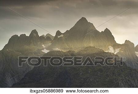 Rugged peaks of the mountain range Trolltindan in the rays of the evening sun, Hadsel, Nordland, Lofoten, Norway, Europe View Large Photo Image Stock Photo - Rugged peaks of the mountain range Trolltindan in the rays of the evening sun, Hadsel, Nordland, Lofoten, Norway, Europe. Fotosearch