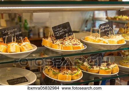 Picture - Small sandwiches snacks Cicchetti in wine bar Cantine del Vino gia Schiavi, Bridge San Trovaso, Dorsoduoro, Venice, Italy, Europe. Fotosearch