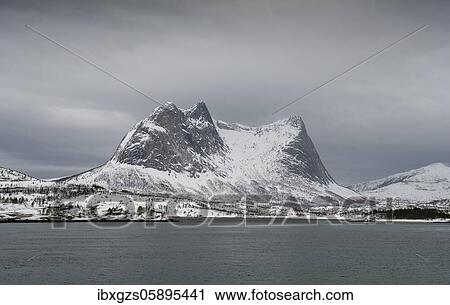 Stock Image - Snowy mountain range Kulhornet, Kobbenestinden, arctic winter landscape, in front sea, Nordland, Norway, Europe. Fotosearch