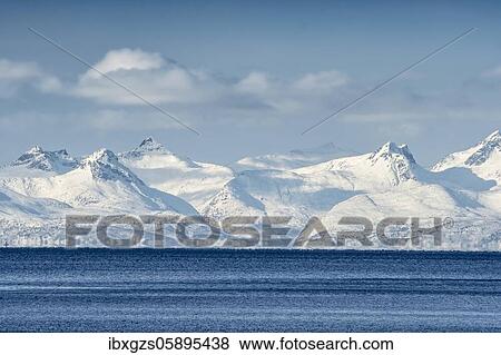 Stock Photo - Snowy mountain range of the Vesteralen in front of the sea, arctic winter landscape, Borkenes, Troms og Finnmark, Norway, Europe. Fotosearch