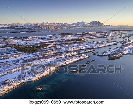 Stock Image - Snowy mountain range Seven Sisters, De syv søstre, Sju søstre, in front winter archipelago in the sea, Dønna, Nordland, Norway, Europe. Fotosearch