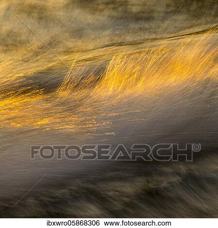 Stock Photograph - Spray, waves on the beach, sunset, long exposure, dynamic range, Porth Nanven, St. Just, Cornwall, Great Britain. Fotosearch