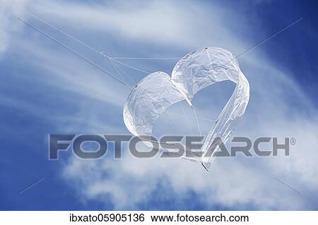 Stock Photograph - Sunlit heart-shaped dragon, white heart in front of blue sky with veil clouds, North Rhine-Westphalia, Germany, Europe. Fotosearch
