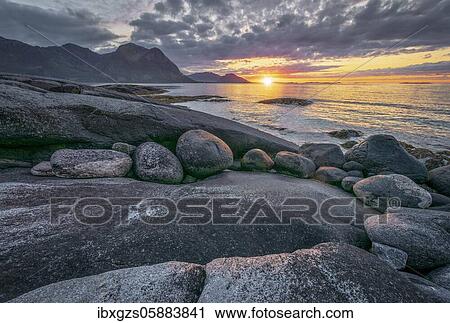Stock Image - Sunset at the sea, in front rocky coast, Ramberg, Napp, Lofoten, Nordland, Norway, Europe. Fotosearch