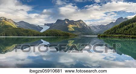 Svartison glacier with glacier tongue, forested mountain range reflected in calm fjord, Meløy, Nordland, Norway, Europe View Large Photo Image Stock Image - Svartison glacier with glacier tongue, forested mountain range reflected in calm fjord, Meløy, Nordland, Norway, Europe. Fotosearch