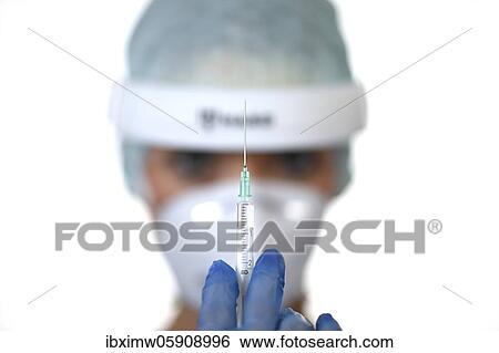 Stock Photograph - Symbol image Corona vaccine, doctor with syringe, corona crisis, Baden-Württemberg, Germany, Europe. Fotosearch