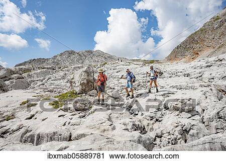 Three hikers in a landscape of washed-out karst rocks, Funtenseetauern, Steinernes Meer, Berchtesgaden National Park, Berchtesgadener Land, Upper Bavaria, Bavaria, Germany, Europe View Large Photo Image Stock Image - Three hikers in a landscape of washed-out karst rocks, Funtenseetauern, Steinernes Meer, Berchtesgaden National Park, Berchtesgadener Land, Upper Bavaria, Bavaria, Germany, Europe. Fotosearch
