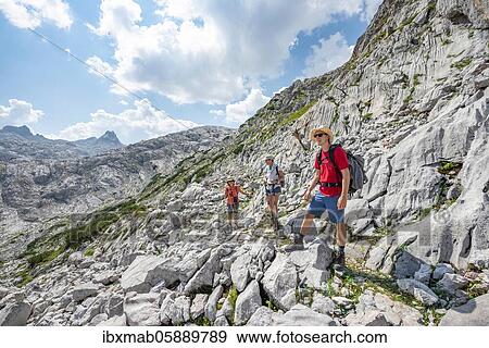 Three hikers in a landscape of washed-out karst rocks, Funtenseetauern, Steinernes Meer, Berchtesgaden National Park, Berchtesgadener Land, Upper Bavaria, Bavaria, Germany, Europe View Large Photo Image Stock Photo - Three hikers in a landscape of washed-out karst rocks, Funtenseetauern, Steinernes Meer, Berchtesgaden National Park, Berchtesgadener Land, Upper Bavaria, Bavaria, Germany, Europe. Fotosearch