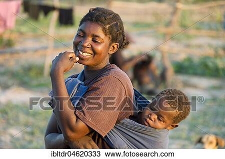 Stock Image - Tonga woman with child on her back, Lake Kariba, Zambia, Africa. Fotosearch