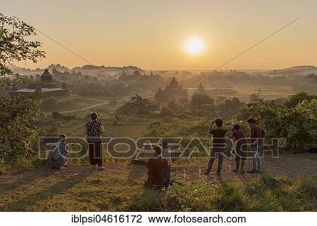 Stock Image - Tourists watch sunset over temples of Mrauk U, Burma, Myanmar, Asia. Fotosearch