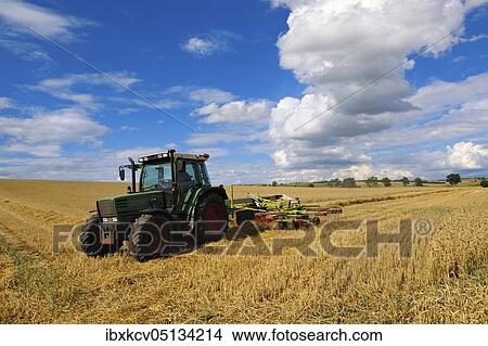 Picture - Tractor working in a cereal field, stubble field, cultivated landscape in summer, blue sky with cumulus clouds, Saalekreis, Saxony-Anhalt, Germany, Europe. Fotosearch