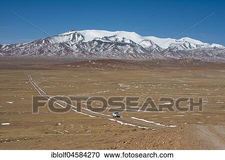 Stock Image - Trail with Landcruiser in front of Mount Amu Kangri, 6108 m, Changtang, Northern Tibet, Tibet, China, Asia. Fotosearch