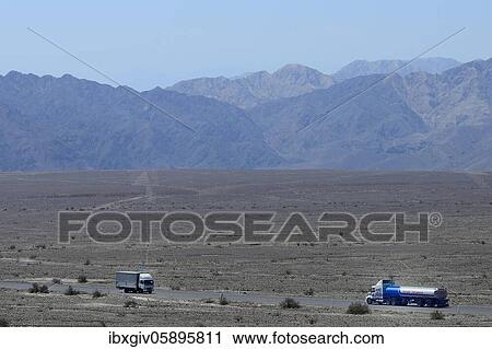 Stock Image - Trucks on the Panamericana drive past the lines of Nasca, Nasca, Ica region, Peru, South America. Fotosearch