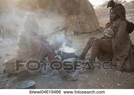 Two hang-girls cooking in front of a mud hut by the fire, Kaokoveld, Kunene, Namibia, Africa View Large Photo Image Stock Photograph - Two hang-girls cooking in front of a mud hut by the fire, Kaokoveld, Kunene, Namibia, Africa. Fotosearch