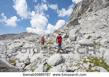 Two hikers in a landscape of washed out karst rocks, Funtenseetauern, Steinernes Meer, Berchtesgaden National Park, Berchtesgadener Land, Upper Bavaria, Bavaria, Germany, Europe View Large Photo Image Stock Photo - Two hikers in a landscape of washed out karst rocks, Funtenseetauern, Steinernes Meer, Berchtesgaden National Park, Berchtesgadener Land, Upper Bavaria, Bavaria, Germany, Europe. Fotosearch