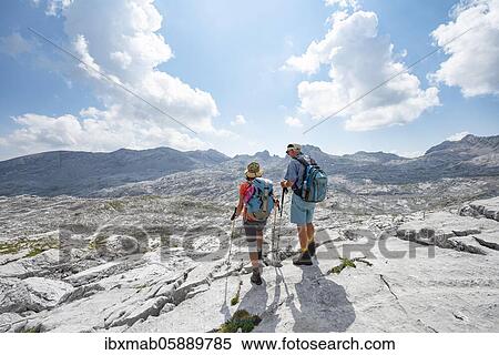 Stock Photography - Two hikers look into the distance, landscape of washed out karst rocks, Funtenseetauern, Steinernes Meer, Berchtesgaden National Park, Berchtesgadener Land, Upper Bavaria, Bavaria, Germany, Europe. Fotosearch