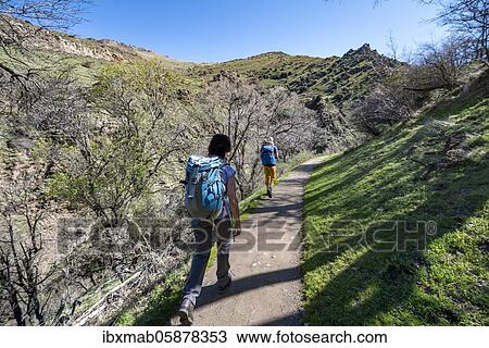 Stock Image - Two hikers on hiking trail Vereda de la Estrella, Sierra Nevada, mountains near Granada, Andalusia, Spain, Europe. Fotosearch