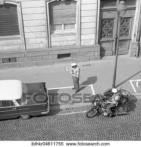 Stock Photography - Two traffic policemen handing out a parking ticket to a car parker around 1950, Freiburg, Germany, Europe. Fotosearch