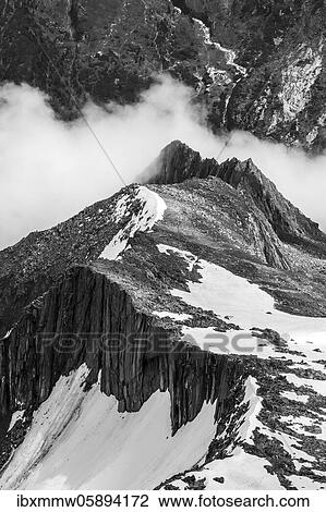 Stock Image - View from the Schönbichler Horn, snow cover high alpine landscape in fog, Berliner Höhenweg, Zillertaler Alps, Zillertal, Tyrol, Austria, Europe. Fotosearch