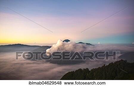 Stock Photo - View of Caldera Tengger with volcanoes at sunrise, smoking volcano Gunung Bromo, with Mt. Batok, Mt. Kursi, Mt. Gunung Semeru, National Park Bromo-Tengger-Semeru, Java, Indonesia, Asia. Fotosearch