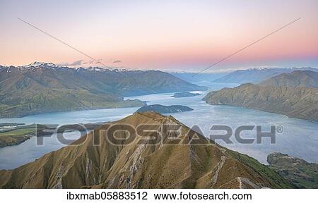 Stock Image - View of mountains and lake from Mount Roy, Roys Peak at sunset, Lake Wanaka, Southern Alps, Otago, South Island, New Zealand, Oceania. Fotosearch