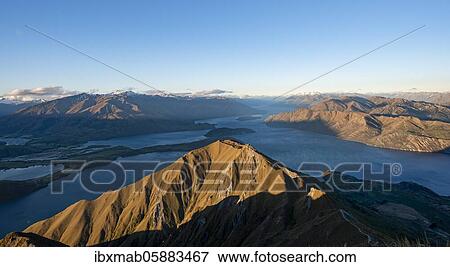 View of mountains and lake from Mount Roy, Roys Peak at sunset, Lake Wanaka, Southern Alps, Otago, South Island, New Zealand, Oceania View Large Photo Image Stock Photo - View of mountains and lake from Mount Roy, Roys Peak at sunset, Lake Wanaka, Southern Alps, Otago, South Island, New Zealand, Oceania. Fotosearch