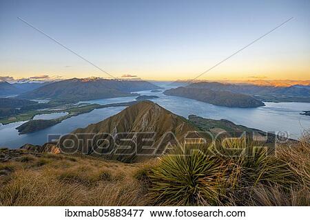 View of mountains and lake from Mount Roy, Roys Peak at sunset, Lake Wanaka, Southern Alps, Otago, South Island, New Zealand, Oceania View Large Photo Image Stock Photo - View of mountains and lake from Mount Roy, Roys Peak at sunset, Lake Wanaka, Southern Alps, Otago, South Island, New Zealand, Oceania. Fotosearch