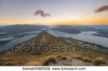 View of mountains and lake from Mount Roy, Roys Peak at sunset, Lake Wanaka, Southern Alps, Otago, South Island, New Zealand, Oceania View Large Photo Image Stock Photo - View of mountains and lake from Mount Roy, Roys Peak at sunset, Lake Wanaka, Southern Alps, Otago, South Island, New Zealand, Oceania. Fotosearch