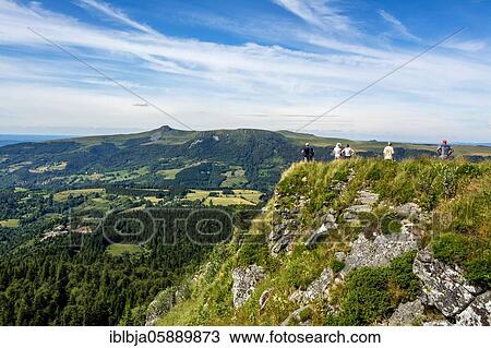Stock Image - Walkers in the Sancy massif at back, Auvergne Volcanoes Natural Park, Puy de Dome department, Auvergne-Rhone-Alpes, France, Europe. Fotosearch