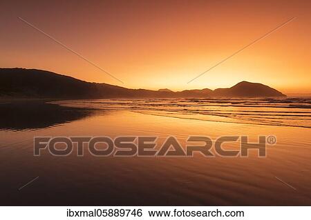 Stock Photograph - Wharariki Beach at sunset, Oceania, Golden Bay, Tasman, South Island, New Zealand, Oceania. Fotosearch