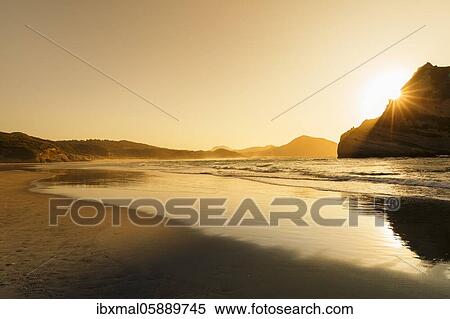 Wharariki Beach at sunset, Oceania, Golden Bay, Tasman, South Island, New Zealand, Oceania View Large Photo Image Stock Photography - Wharariki Beach at sunset, Oceania, Golden Bay, Tasman, South Island, New Zealand, Oceania. Fotosearch