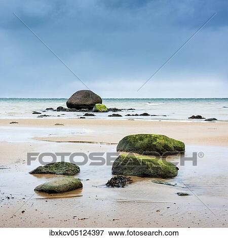 Stock Photo - Winter at the Baltic Sea, erratic blocks on the beach, dark clouds above the sea, near Wismar, Mecklenburg-Vorpommern, Germany, Europe. Fotosearch