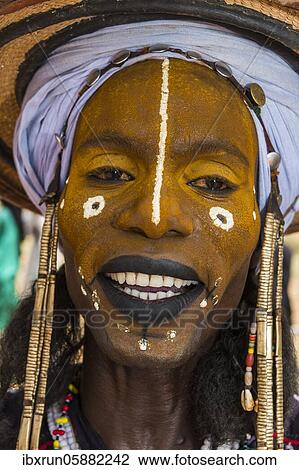 Stock Image - Wodaabe-Bororo man with faces painted at the annual Gerewol festival, courtship ritual competition among the Fulani ethnic group, Niger, Africa. Fotosearch
