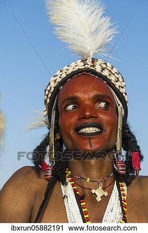 Stock Image - Wodaabe-Bororo man with his face painted at the annual Gerewol festival, courtship ritual competition among the Fulani ethnic group, Niger, Africa. Fotosearch