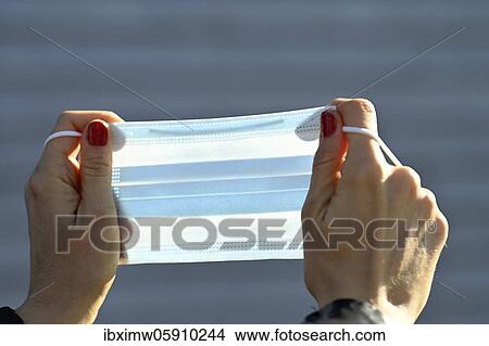 Picture - Woman putting on a face mask, portrait, corona crisis, Stuttgart, Baden-Württemberg, Germany, Europe. Fotosearch