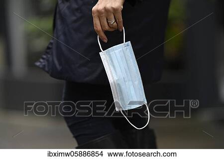 Picture - Woman wearing a face mask in her hand, detail view, corona crisis, Stuttgart, Baden-Württemberg, Germany, Europe. Fotosearch