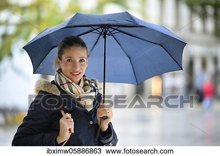 Stock Image - Woman with in winter clothes with umbrella, portrait, Stuttgart, Baden-Württemberg, Germany, Europe. Fotosearch