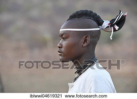 Stock Image - Young Himba man with traditional hairstyle, Portrait, Kaokoveld, Namibia, Africa. Fotosearch