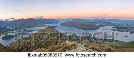 Young man standing on the summit, view of mountains and lake from Mount Roy, Roys Peak at sunset, Lake Wanaka, Southern Alps, Otago, South Island, New Zealand, Oceania View Large Photo Image Stock Image - Young man standing on the summit, view of mountains and lake from Mount Roy, Roys Peak at sunset, Lake Wanaka, Southern Alps, Otago, South Island, New Zealand, Oceania. Fotosearch