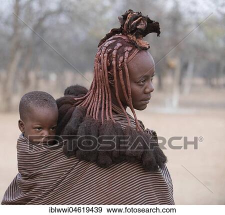 Young, married woman wearing a baby in a cloth, portrait, Kaokoveld, Namibia, Africa View Large Photo Image Stock Photo - Young, married woman wearing a baby in a cloth, portrait, Kaokoveld, Namibia, Africa. Fotosearch