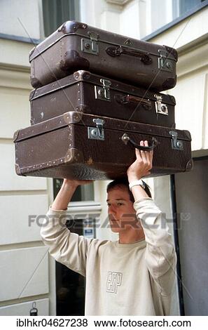 Young person carries three suitcases, Berlin, Germany, Europe View Large Photo Image Stock Photo - Young person carries three suitcases, Berlin, Germany, Europe. Fotosearch
