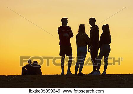 Young woman and men, twilight, talking, Baden-Württemberg, Germany, Europe View Large Photo Image Stock Photo - Young woman and men, twilight, talking, Baden-Württemberg, Germany, Europe. Fotosearch