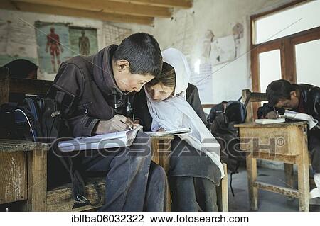 A boy and a girl writing in an exercise book on a school desk, classroom, Potokh Primary School, Potokh, Wakhan Corridor, Afghanistan, Asia View Large Photo Image Stock Image - A boy and a girl writing in an exercise book on a school desk, classroom, Potokh Primary School, Potokh, Wakhan Corridor, Afghanistan, Asia. Fotosearch