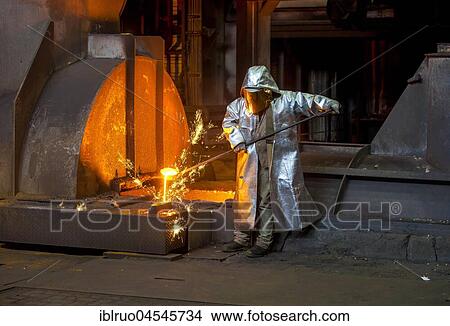 Picture - A steel worker in a protective suit taking a 1500 ° hot raw iron sample at the tapping, furnace 8, ThyssenKrupp ironworks, Duisburg, Ruhr area, North Rhine-Westphalia, Germany, Europe. Fotosearch