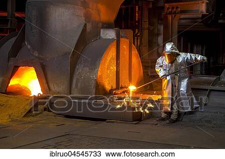 Stock Image - A steel worker in a protective suit taking a 1500 ° hot raw iron sample at the tapping, furnace 8, ThyssenKrupp ironworks, Duisburg, Ruhr area, North Rhine-Westphalia, Germany, Europe. Fotosearch