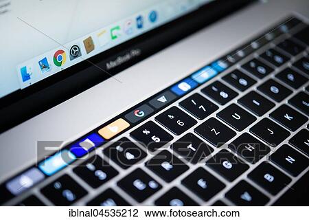 Stock Image - Backlit keyboard and Touch Bar showing websites, laptop, Apple MacBook Pro, close-up. Fotosearch